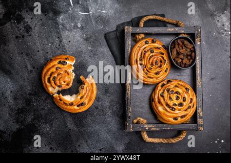 Dänische Rosinengebäck-Strudel. Schwarzer Hintergrund. Draufsicht. Stockfoto