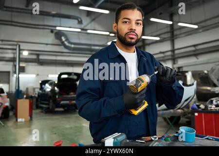 Ein erfahrener Mechaniker konzentrierte sich auf seine Aufgabe in einer hellen und geräumigen Autowerkstatt Stockfoto