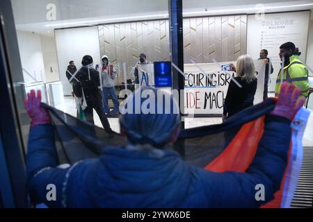 Bimingham, England, Großbritannien. Dezember 2024. Aktivisten protestieren im Empfangsbereich des Bürogebäudes, während Unterstützer während der Demonstration ihre rot bedeckten Hände auf das Glas drücken. Pro-palästinensische Aktivisten zielen auf die Versicherungsbüros der Allianz in ihrem Colmore Building in Birmingham, die den Empfangsbereich besetzen und draußen protestieren. Sie zielen auf die Allianz ab, weil sie das israelische Rüstungsunternehmen Elbit Systems versichern und in das israelische Rüstungsunternehmen Elbit Systems investieren und entschlossen sind, den Druck des direkten Handelns aufrecht zu erhalten, damit es zu einem großen Nachteil wird, mit ihnen zusammenzuarbeiten. Sie verlangen, dass die Firma Elbit Systems abwirft. Stockfoto