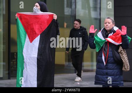 Bimingham, England, Großbritannien. Dezember 2024. Aktivisten mit palästinensischen Fahnen und roten Händen protestieren, während Arbeiter während der Demonstration geschickt werden, um Zugang zum Gebäude um den Rücken zu erhalten. Pro-palästinensische Aktivisten zielen auf die Versicherungsbüros der Allianz in ihrem Colmore Building in Birmingham, die den Empfangsbereich besetzen und draußen protestieren. Sie zielen auf die Allianz ab, weil sie die israelische Rüstungsfirma Elbit Systems versichern und in diese investieren. Sie verlangen, dass die Firma Elbit Systems abwirft. (Kreditbild: © Martin Pope/ZUMA Press Wire) NUR REDAKTIONELLE VERWENDUNG! Nicht für kommerzielle ZWECKE! Stockfoto