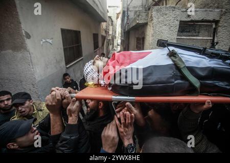 Nablus, Palästina. Dezember 2024. Bewaffnete Männer und palästinensische Menschenmengen verabschieden sich von der Leiche des jungen palästinensischen Jihad Abu Salim (27 Jahre alt). Der palästinensische Jihad Abu Salima, Mitglied der Al-Aqsa Märtyrer Brigaden, dem militärischen Flügel der Fatah-Bewegung, wurde während eines Feuerwechsels zwischen den israelischen Besatzungskräften während des Sturms auf das Lager Balata zum Märtyrer erklärt. Zwei Palästinenser wurden bei den Zusammenstößen während der Militäroperation ebenfalls verletzt. Quelle: SOPA Images Limited/Alamy Live News Stockfoto