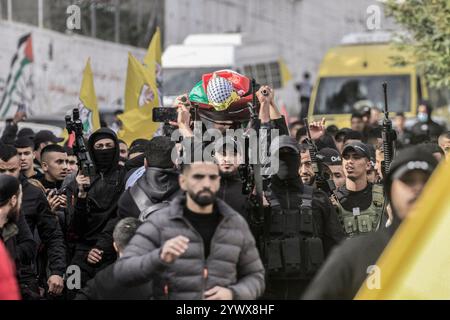 Nablus, Palästina. Dezember 2024. Bewaffnete Männer und palästinensische Menschenmengen verabschieden sich von der Leiche des jungen palästinensischen Jihad Abu Salim (27 Jahre alt). Der palästinensische Jihad Abu Salima, Mitglied der Al-Aqsa Märtyrer Brigaden, dem militärischen Flügel der Fatah-Bewegung, wurde während eines Feuerwechsels zwischen den israelischen Besatzungskräften während des Sturms auf das Lager Balata zum Märtyrer erklärt. Zwei Palästinenser wurden bei den Zusammenstößen während der Militäroperation ebenfalls verletzt. Quelle: SOPA Images Limited/Alamy Live News Stockfoto