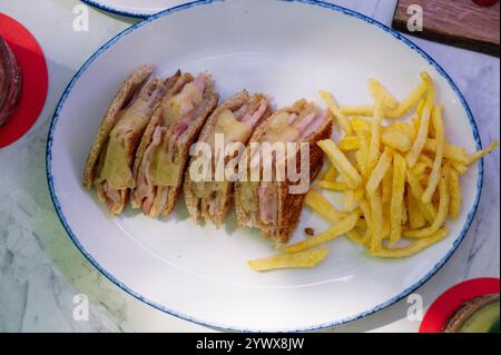 Drei gegrillte Schinken-Käse-Sandwiches mit Pommes frites. Stockfoto