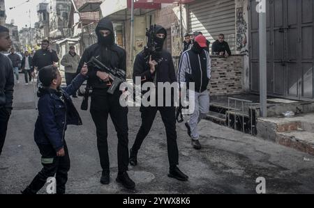 Nablus, Palästina. Dezember 2024. Bewaffnete Männer durchstreifen den Markt nach der Ermordung des palästinensischen Jugendlichen Jihad Abu Salim (27 Jahre alt). Der palästinensische Jihad Abu Salima, Mitglied der Al-Aqsa Märtyrer Brigaden, dem militärischen Flügel der Fatah-Bewegung, wurde während eines Feuerwechsels zwischen den israelischen Besatzungskräften während des Sturms auf das Lager Balata zum Märtyrer erklärt. Zwei Palästinenser wurden bei den Zusammenstößen während der Militäroperation ebenfalls verletzt. Quelle: SOPA Images Limited/Alamy Live News Stockfoto