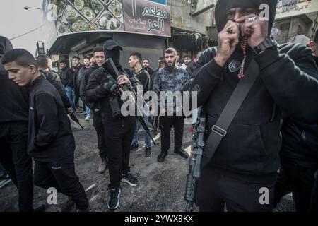 Nablus, Palästina. Dezember 2024. Bewaffnete Männer durchstreifen den Markt nach der Ermordung des palästinensischen Jugendlichen Jihad Abu Salim (27 Jahre alt). Der palästinensische Jihad Abu Salima, Mitglied der Al-Aqsa Märtyrer Brigaden, dem militärischen Flügel der Fatah-Bewegung, wurde während eines Feuerwechsels zwischen den israelischen Besatzungskräften während des Sturms auf das Lager Balata zum Märtyrer erklärt. Zwei Palästinenser wurden bei den Zusammenstößen während der Militäroperation ebenfalls verletzt. Quelle: SOPA Images Limited/Alamy Live News Stockfoto