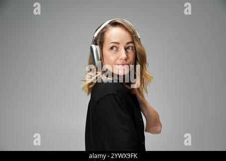 Eine schöne junge Frau mit Vitiligo posiert selbstbewusst, während sie Kopfhörer in einem Studio trägt. Stockfoto