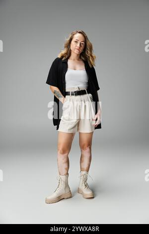 Die junge Frau zeigt ihre Schönheit und Selbstvertrauen in einem stilvollen Outfit. Stockfoto