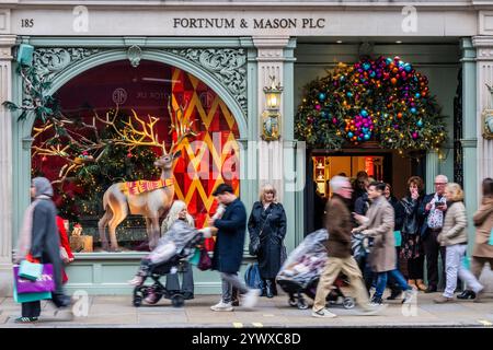 London, Großbritannien. Dezember 2024. Fortnum & Mason, auf Piccadilly, ist sehr beschäftigt mit Einkäufern, die ihre festlichen Schaufensterausstellungen (einschließlich eines von Santas Rentier) in der Weihnachtszeit genießen. Guy Bell/Alamy Live News Stockfoto