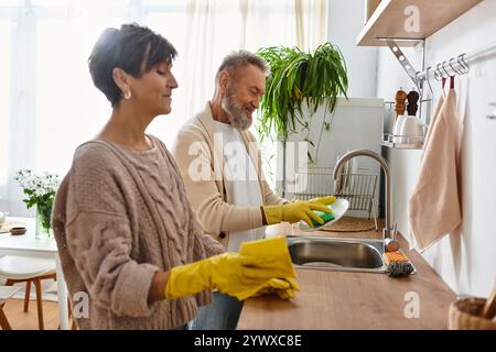 Ein Paar teilt einen freudigen Moment in ihrer gemütlichen Küche, reinigt und organisiert gemeinsam. Stockfoto