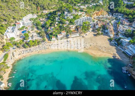 Aus der Vogelperspektive auf Cala Vadella, Ibiza, mit türkisfarbenem Wasser, Segelbooten, Sandstränden, und Luxusvillen Stockfoto