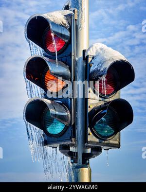 Gefrorenes Verkehrslicht bedeckt mit Eis während des Wintersturms an einem schneebedeckten Tag Stockfoto