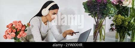 Eine engagierte Blumenhändlerin arrangiert wunderschöne Blumen und verwaltet dabei ihre kleinen Geschäfte, Banner Stockfoto