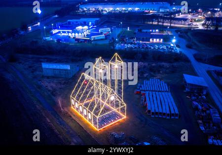 Fahrbinde, Deutschland. Dezember 2024. Die Weihnachtskirche, die in den letzten Tagen von Gerüsten errichtet und mit Feenlichtern beleuchtet wurde, leuchtet am Ortsrand. (Luftaufnahme mit Drohne) das Gerüst mit zwei rund 24 Meter hohen Türmen ist heute die siebte Weihnachtskirche. Der präzise geplante Bau der Autobahn zwischen Berlin und Hamburg wird bis Ende Januar jeden Abend leuchten. Quelle: Jens Büttner/dpa/Alamy Live News Stockfoto