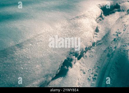 Funkelnde, glitzernde tiefe Schneewehung zur goldenen Stunde, Licht und Schatten auf dickem weißen Schnee Textur Hintergrund, festliche weihnachtsfeiertage Saison n Stockfoto