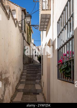 Vertikale Ansicht einer schmalen Straße, typisch für das Viertel Albaicín von Granada, das zum Weltkulturerbe gehört Stockfoto
