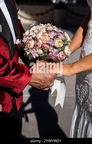Braut und Bräutigam halten die Hände kurz nach der Zeremonie am Hochzeitstag, Happy Frischvermählte - Bild Stockfoto