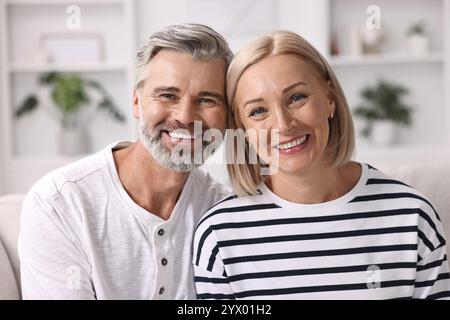Porträt eines glücklichen Paares mittleren Alters drinnen Stockfoto