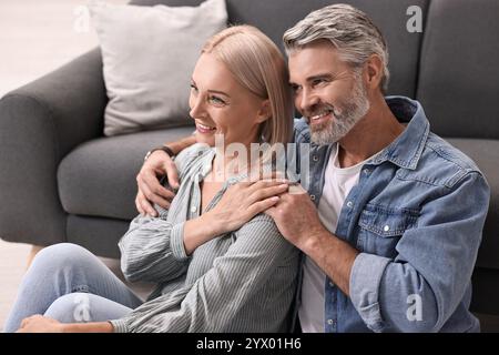 Glückliches Paar mittleren Alters zu Hause auf dem Stockwerk Stockfoto