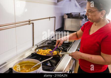 Der lateinamerikanische Küchenchef bereitet traditionelle ecuadorianische Gerichte in der Restaurantküche zu Stockfoto