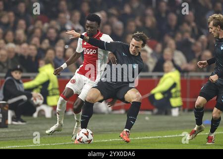 AMSTERDAM - (l-r) Bertrand Traore von Ajax, Luca Pellegrini von SS Lazio, Nicolo Ravella von SS Lazio während des UEFA Europa League Spiels zwischen AFC Ajax Amsterdam und SS Lazio Roma in der Johan Cruijff Arena am 12. Dezember 2024 in Amsterdam, Niederlande. ANP | Hollandse Hoogte | MAURICE VAN STEEN Credit: ANP/Alamy Live News Stockfoto