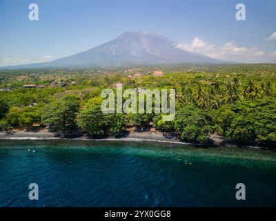 TAUCHEN SIE Taucher auf dem Schiffswrack der USAT Liberty in Tulamben, Bali, mit dem hoch aufragenden Vulkan Mount Agung dahinter Stockfoto