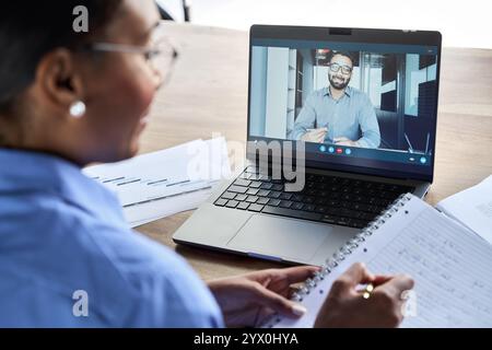 Professionelle Geschäftsfrau, die ein virtuelles Meeting hat. Über der Schulter. Stockfoto