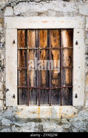 Rostiges Metallfenster mit Metallstangen und Holzdielen Stockfoto