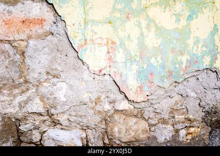 Strukturierte Wand, die bröckelnd in Gelb und Hellgrün gefärbt ist Stockfoto