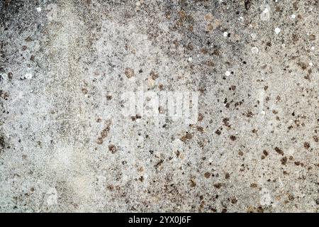 Graue Wandstruktur mit dunklen Flecken. Stockfoto