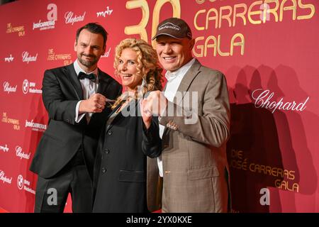 Leipzig - Spendengala im Kampf gegen Leukämie: Dutzende Sterne bei der 30. JosÃ Carreras Gala 12.12.2024 ab 18 Uhr Leipzig, Media City Leipzig Fotograf: EHL Media/Dietmar Thomas im Foto: Victoria Herrmann, Moderatorin mit Ehemann David Böthig links und Axel Schulz, Boxer am Donnerstag überträgt der MDR ab 20,15 Uhr live aus Leipzig die 30. JosÃ Carreras Gala. Gastgeber und Stifter JosÃ Carreras wird in seiner großen Vision Leukämie muss heilbar werden. Immer und bei jedem wieder von prominenten internationale und nationale Künstlerfreunden unterstützt. Gemeinsam mit Gastgeber JosÃ Carreras wer Stockfoto