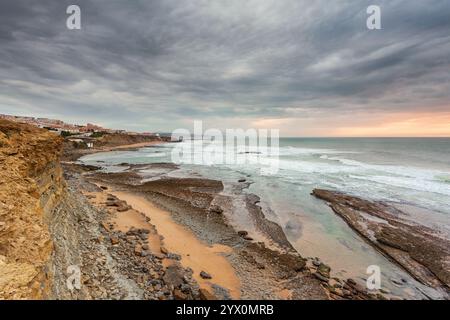 Meereslandschaft am Strand Ericeira,. Explosiver Sonnenuntergang in intensiver Farbfotografie. Ebbe und der Schaum zwischen den Felsen Portugal Meereslandschaft. Li Stockfoto