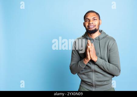 Ein hoffnungsvoller afroamerikaner bettelt und bittet um etwas, bittet um Vergebung oder Barmherzigkeit und ist traurig. Armer Bettler bittet um Hilfe, fleht und ist verzweifelt. Stockfoto