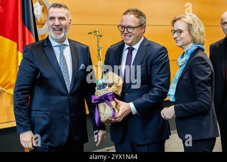 Von links: Steffen Schütz Stellvertretender Fraktionsvorsitzender BSW gratuliert Mario Voigt CDU, Ministerpräsident mit einem Brombeer-Strauch Katja Wolf Fraktionsvorsitzende BSW, 12.12.2024, Erfurt Deutschland, Politik, Thüringer Landtag, Wahl des Ministerpräsidenten *** von links Steffen Schütz Stellvertretender Vorsitzender der BSW-Fraktion gratuliert Mario Voigt CDU, Ministerpräsident mit brombeerbusch Katja Wolf Vorsitzende der BSW-Fraktion , 12 12 2024, Erfurt Deutschland , Politik, Thüringer Parlament, Wahl des Ministerpräsidenten xprx Stockfoto