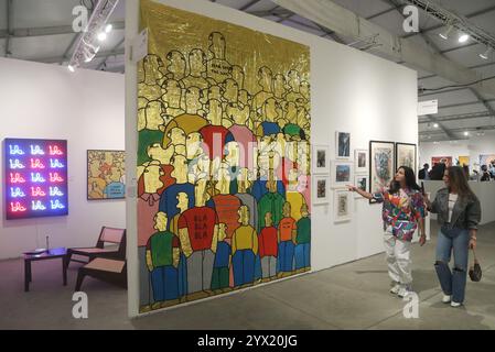 MIAMI, FLORIDA - 5. DEZEMBER: Gemälde von stilisierten Figuren aus Acryl auf Wärmebüchern mit dem Titel Crowd (2023) von Fabrizio Dusi präsentiert von Mazzucchelli Art Consulting auf der Context Art Miami im Rahmen der Miami Art Week am 5. Dezember 2024 in Miami, Florida. (Foto: Sean Drakes/Alamy) Stockfoto