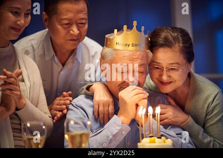 Glücklicher älterer asiatischer alter Mann, der nachts mit älteren Freunden Geburtstag feiert Stockfoto