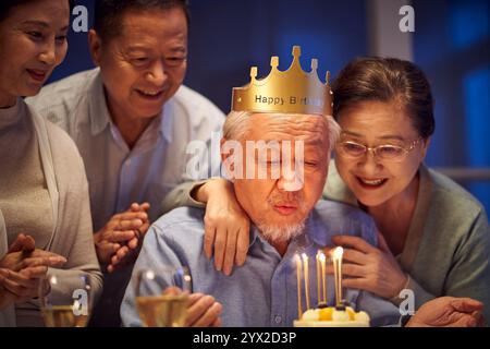 Glücklicher älterer asiatischer alter Mann, der nachts mit älteren Freunden Geburtstag feiert Stockfoto