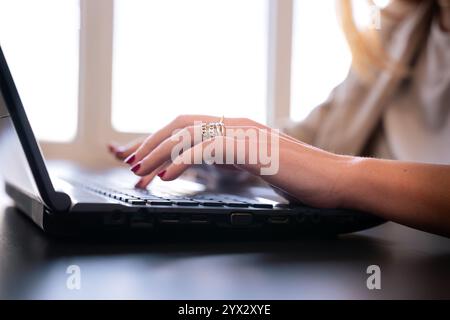 Unerkennbare Frau, die in modernen Büroumgebungen am Laptop arbeitet Stockfoto