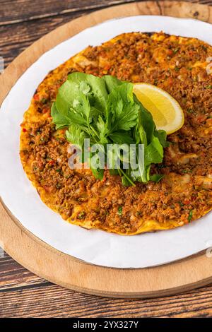 Lahmacun mit Rucola auf einem Schneidebrett auf Holztisch Stockfoto