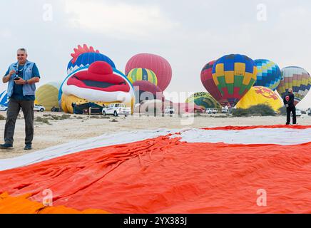 QATAR BALLOON FESTIVAL 2024 Teilnehmer bereiten während des Qatar Balloon Festival 2024 in Doha, Katar, am 13. Dezember 2024 einen Heißluftballon vor. Die 5. Ausgabe des Qatar Balloon Festivals fand hier vom 12. Bis 22. Dezember statt, und mehr als 50 Teilnehmer nehmen am Festival DOHA Qatar Teil Copyright: XNOUSHADx Stockfoto
