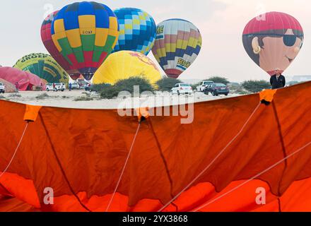 QATAR BALLOON FESTIVAL 2024 Teilnehmer bereiten während des Qatar Balloon Festival 2024 in Doha, Katar, am 13. Dezember 2024 einen Heißluftballon vor. Die 5. Ausgabe des Qatar Balloon Festivals fand hier vom 12. Bis 22. Dezember statt, und mehr als 50 Teilnehmer nehmen am Festival DOHA Qatar Teil Copyright: XNOUSHADx Stockfoto
