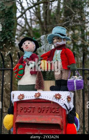 Rote Royal Mail Postbox mit gestrickter Weihnachtsdekoration oder Garn Bombing, Overstone, Northamptonshire, UK Stockfoto