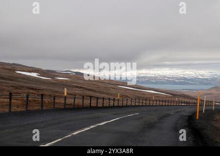 Blick entlang der Bergstraße zur Küste, mit schneebedeckten Bergen in der Ferne Stockfoto