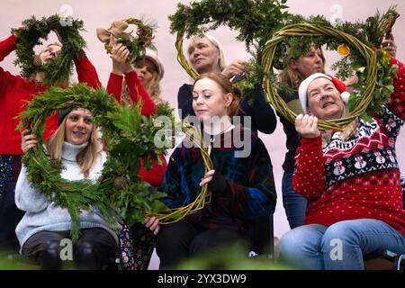 12/24 Eine Gruppe von Damen lernt, Weihnachtskränze in einer Werkstatt im Whistlewood Common, Melbourne Derbyshire zu machen. Die festliche Dekoration Stockfoto