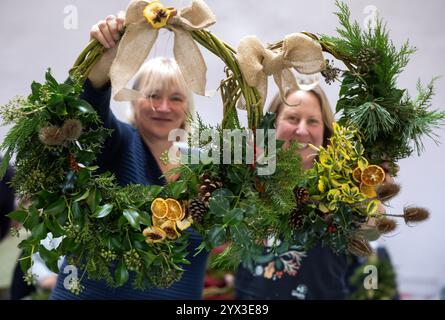 12/24 Eine Gruppe von Damen lernt, Weihnachtskränze in einer Werkstatt im Whistlewood Common, Melbourne Derbyshire zu machen. Die festliche Dekoration Stockfoto