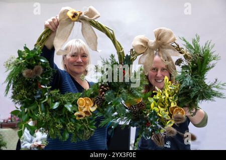 12/24 Eine Gruppe von Damen lernt, Weihnachtskränze in einer Werkstatt im Whistlewood Common, Melbourne Derbyshire zu machen. Die festliche Dekoration Stockfoto