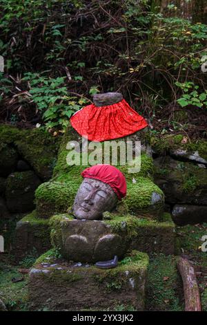 Eine kopflose buddha-Statue ist in Japan mit Moos bewachsen. Stockfoto