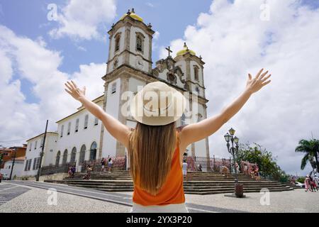 Tourismus in Salvador de Bahia, Brasilien. Touristenmädchen, das die historische Stadt Salvador de Bahia besucht. Mädchen mit erhobenen Armen vor der Kirche Noss Stockfoto