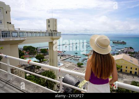 Tourismus in Salvador de Bahia, Brasilien. Reisende Mädchen auf der Terrasse und genießen den Aussichtspunkt mit Lacerda Aufzug und Hafen von Salvador de Bahia, Brasilien. Stockfoto