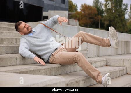 Mann, der draußen auf Treppen fällt. Gefährlicher Unfall Stockfoto