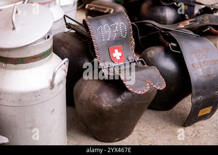 LAUTERBRUNNEN, SCHWEIZ - 23. SEPTEMBER 2023: Alte Kuhhalsglocken mit Schweizer Flagge und Milchkanne während des Desaple Festivals. Stockfoto